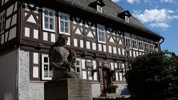 Das Geburtshaus Friedrich Fröbels in Oberweißbach: ein Fachwerkhaus, davor eine Büste