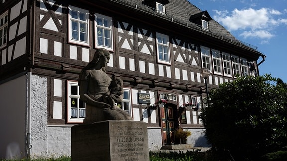 Das Geburtshaus Friedrich Fröbels in Oberweißbach: ein Fachwerkhaus, davor eine Büste