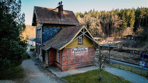 Bahnhof Paulinzella: ein Gebäude aus roten Backsteinen mit der Aufschrift Paulinzella