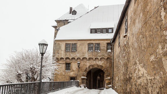 Schloss Blankenburg im Schnee, ein Weg führt auf ein Tor zu