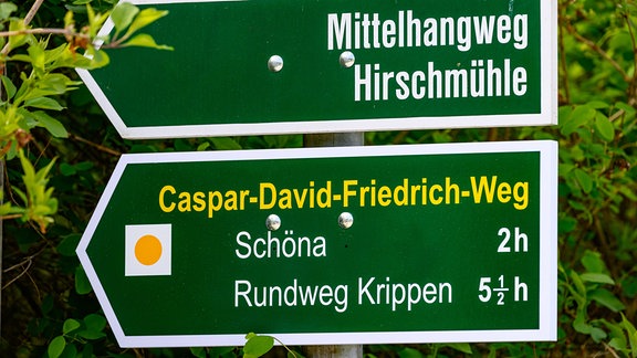 Ein Richtungspfeil für den Caspar-David-Friedrich Weg in der Sächsischen Schweiz steht an einem Weg an der Elbe.