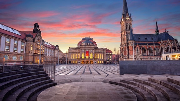 Stadtbild von Chemnitz mit der Chemnitzer Oper und der St. Petri-Kirche bei schönem Sonnenuntergang. 