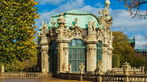 Der Dresdner Zwinger mit Wallpavillon im Herbst. Ein prunkvolles Gebäude mit vielen Fenstern bis zum Boden