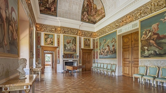 Festsaal Schloss Wörlitz: ein raum mit goldenen Verzierungen, großen Gemälden und weißer Vertäfelung
