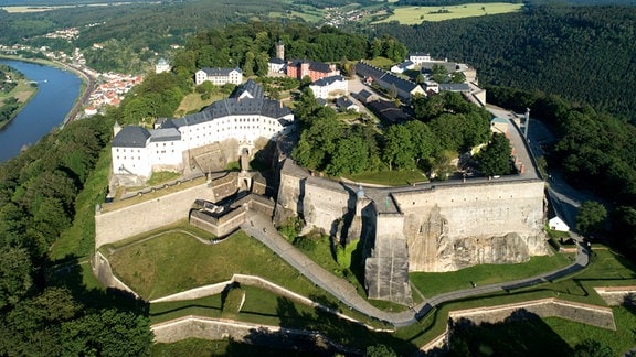 Festung Königstein aus der Vogelperspektive: eine Festung umgeben von Wald und der Elbe