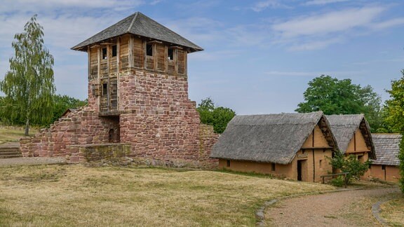 Ein alter Turm aus Stein, der Teil einer Siedlung aus dem Mittelalter ist.
