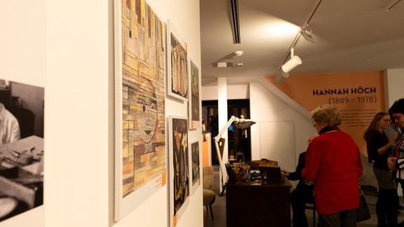 An einer Wand hängen Bilder von Hannah Höch, der Ausstellungsraum ist gut besucht.