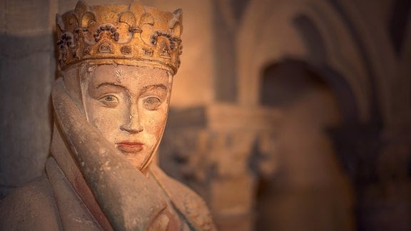 Nahaufnahme einer Skulptur: Eine Frau mit Kopftuch, Krone und weichen Gesichtszügen.