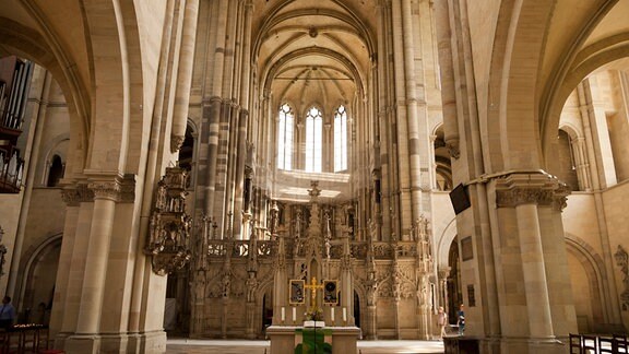 Innenraum des Magdeburger Doms mit gotischen Bögen, am Ende des Kirchenschiffes sind drei Fenster