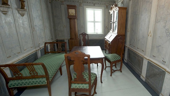 Blick in das historische Schillerzimmer mit Sekretär, Standuhr, Bett, Tisch und Stühlen im Neuen Schillerhaus Bad Lauchstädt.