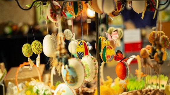 Verschieden dekorierte Eier hängen an einem Stand.