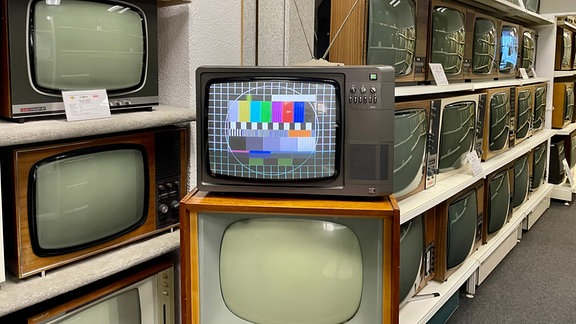 Ein altes Fernsehgerät mit Antenne zeigt ein Testbild. 