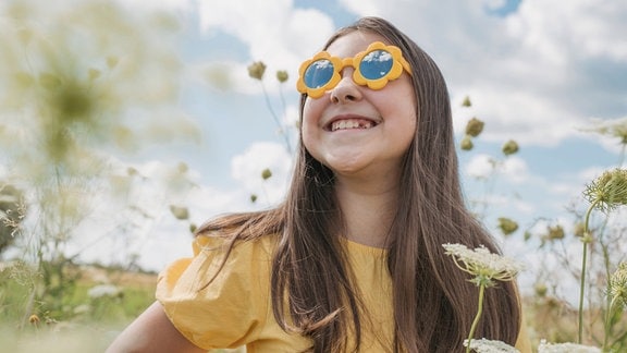 Ein Mädchen mit einer gelben Sonnenbrille