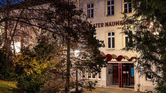 Nacht/Außen/Quer: Theater Naumburg. Außenfront mit Eingang und Schriftzug und Baum (re.)