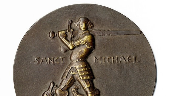 Bild einer Bronzemedaille, die einen Mann mit einem Schwert in der Hand zeigt. 