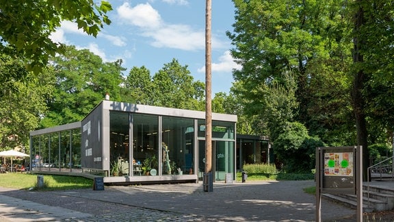 Galerie für Zeitgenössische Kunst Leipzig, ein flacher Glausbau, umgeben von Bäumen. 