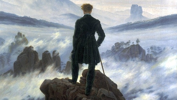 Gemälde, ein Mann steht auf einem hohen Felsen, vor ihm eine Landschaft mit Felsen und Nebelschwaden.