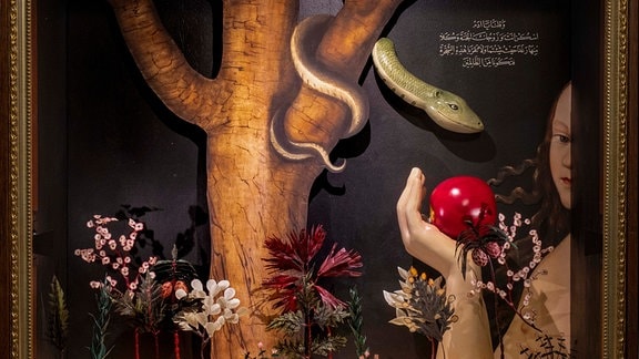 Bild einer Schlange, die sich um einen Baumstamm wickelt, davor eine Frauenhand mit einem Apfel.