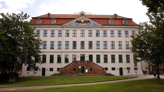 Franckesche Stiftungen Halle: ein mehrgeschossiges, imposantes Gebäude mit rotem Dach. Davor ein Treppenaufgang aus roten Steinen.