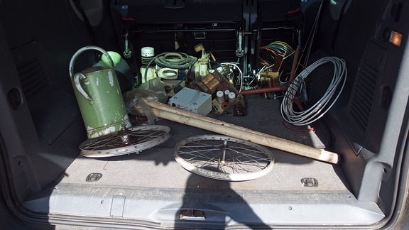 Sammelsurium alter Auto-Ersatzteile auf der Ladefläche eines Transporters