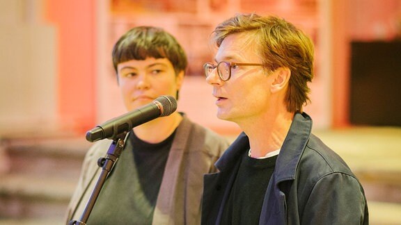 Ein weißer Mall mit brille und aschblondem Haar spricht in ein Mikrofon - es ist Clemens von Wedemeyer, Professor an der Hochschule für Grafik und Buchkunst.