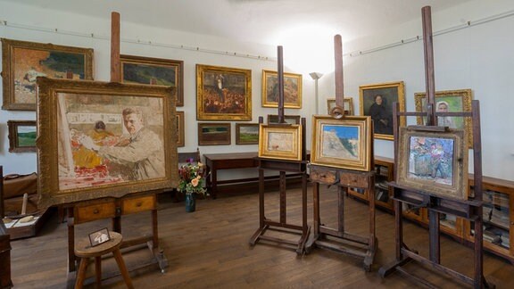 Malermuseum Robert Sterl Haus: ein Zimmer voller Gemälde an den Wänden und auf Staffeleien