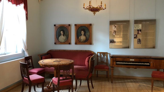 Zimmer mit Sitzecke, Gemälden und Schautafeln im Romantikerhaus Jena