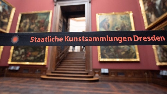 Ein Absperrband mit der Aufschrift «Staatliche Kunstsammlungen Dresden» hängt in der Gemäldegalerie Alte Meister vor den Gemälden. 