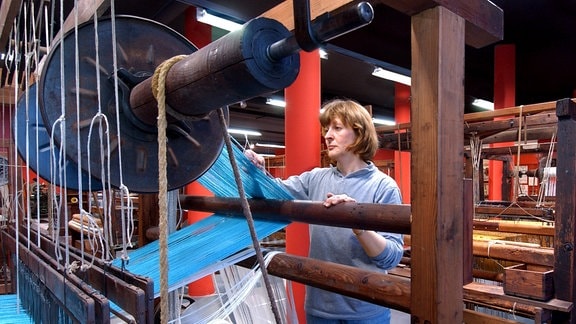 Eine Handwebermeisterin richtet im neuen "webMuseum" in Oederan vor der Eröffnung einen der zwölf historischen Handwebstühle ein