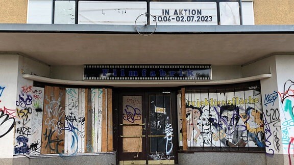 Blick auf den mit Graffiti überzogenen Eingang eines ehemaligen Kinos