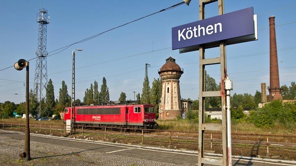 Ein E-Lok steht unweit eines Wasserturmes im Bahnhof der Stadt Köthen im Kreis Anhalt-Bitterfeld