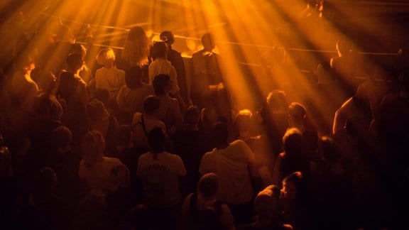 Einige dutzend Menschen stehen vor einer Bühne des historischen Kinosaals im UT Connewitz in Leipzig,