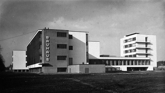 Schwarz-Weiß-Bild des Dessauer Bauhauses: Ein Komplex mit mehreren Kastenbauten.