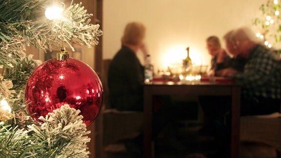 Familie sitzt an Heiligabend gemeinsam am Tisch