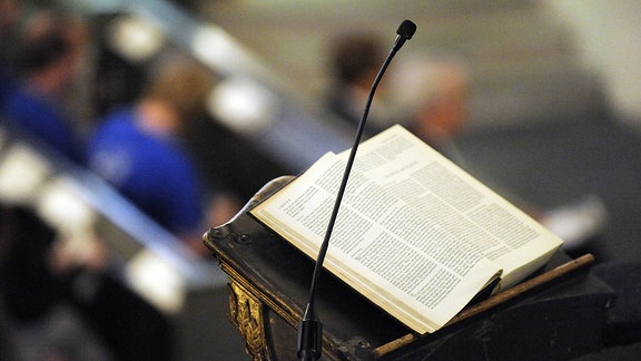 Aufgeschlagene Bibel neben einem Mikrofon