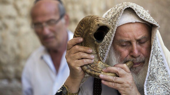 Ein orthodoxer jude bläst an der Klagemauer in Jerusalem, Israel, ein Schofar, das Horn eines Widders.