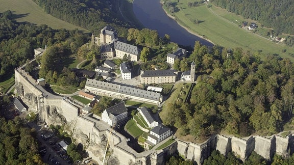 Luftbild der Festung Königstein, sie ist von vielen Bäumen umgeben