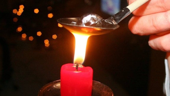 Ein Bleistück wird über einer Kerze zum Schmelzen gebracht
