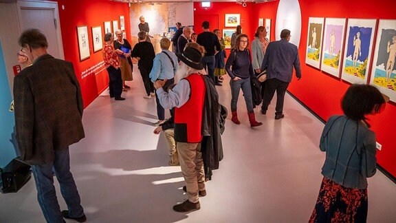Besucher betrachten Bilder bei der Eröffnung der Ausstellung "Westlöffel & Ostkaffe" im Feininger Museum