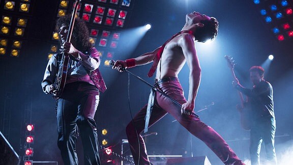 Szene aus dem Film "Bohemian Rhapsody", in der Freddie Mercury auf der Bühne steht. 