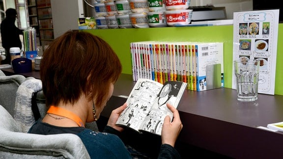 Eine junge Frau liest in einem Manga 