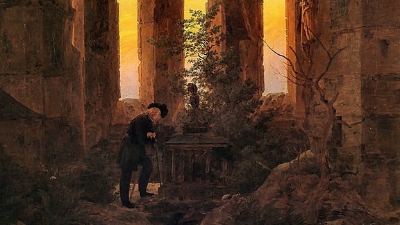 Ein Gemälde von Friedrich Caspar David, das eine Kirchenruine zeigt, in der Mitte ein Sarkophag, neben dem ein Mann steht.
