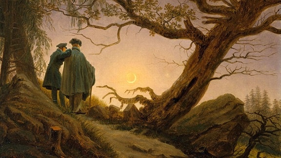 Zwei Männer stehen in einer Wald-Landschaft und betrachten den Mond