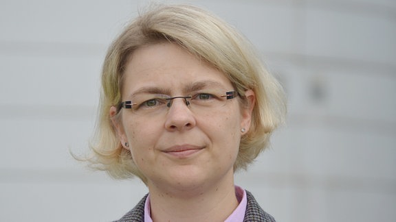 Porträt von Daniela Sammler: Eine Frau mit Brille und blonder Kurzhaarfrisur.