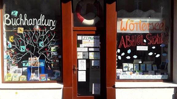 Connewitzer Verlagsbuchhandlung, ein Laden mit Eingangstür und dekorierten Schaufenstern