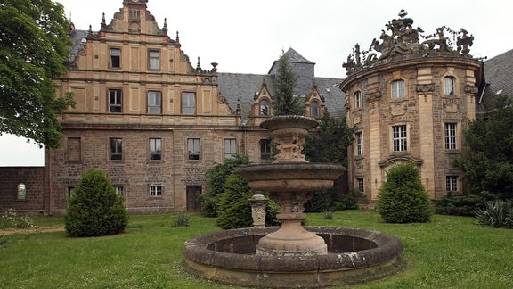 Schloss Vitzenburg: ein historisches Gebäude mit verzierten Giebeln, davor ein Springbrunnen und Garten