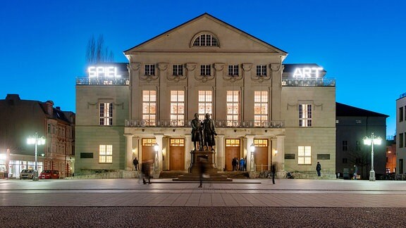 Das Gebäude des Deutschen Nationaltheaters Weimar wird in der blauen Stunde angestrahlt.