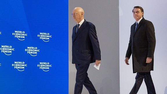 Prof. Klaus Schwab und Brasiliens Präsident Jair Bolsonaro betreten die Bühne beim Weltwirtschaftsforum in Davos 2019.
