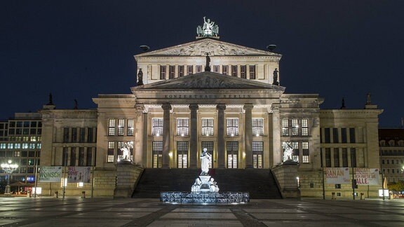 Repräsentatives Gebäude mit Säulen und Treppen, beleuchtet bei Nacht am Gendarmenmarkt in Berlin