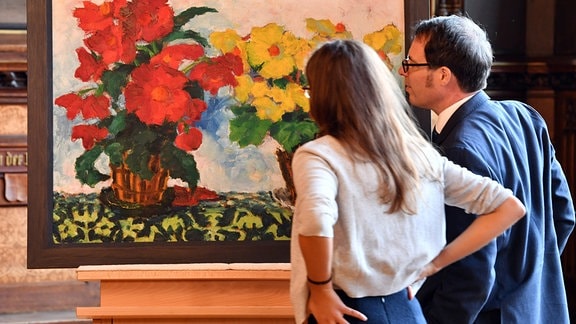 Eine Frau und ein Mann betrachten ein Gemälde.